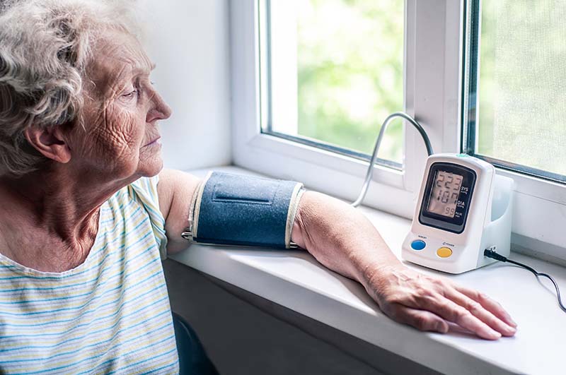 Mulher idosa medindo a pressão arterial