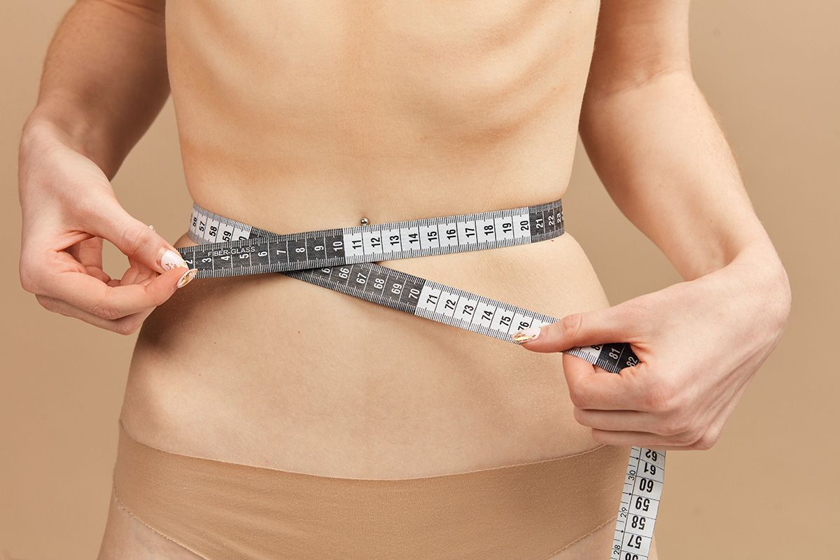 Mulher mede a cintura: Como identificar um transtorno alimentar