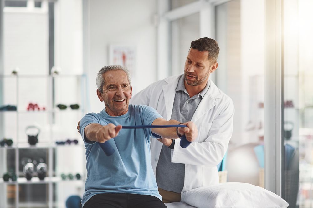 Idoso feliz fazendo exercício com seu fisioterapeuta